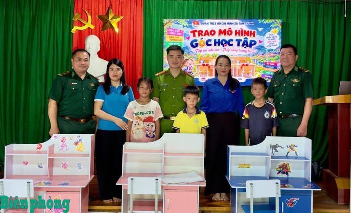 Cán bộ, chiến sĩ Đồn Biên phòng Tam Thanh, Bộ đội Biên phòng tỉnh Thanh Hóa, cùng đại diện Đoàn Thanh niên Cộng sản Hồ Chí Minh xã Tam Thanh trao tặng học sinh những bộ bàn học kèm giá sách theo mô hình “Góc học tập”, tạo thêm điều kiện để các em học tập tốt hơn. Ảnh: Trương Tùng