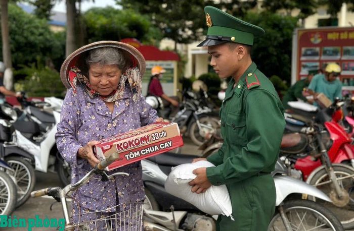 Chiến sĩ Đồn Biên phòng cửa khẩu quốc tế Hà Tiên hỗ trợ người già nhận quà. Ảnh: Văn Nhòa