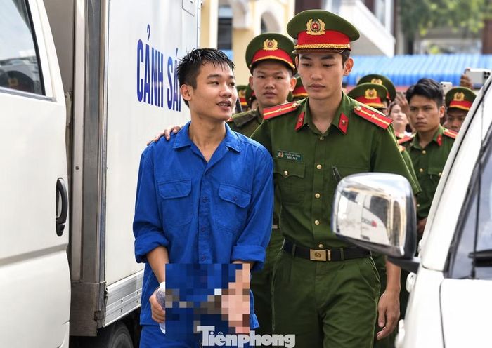 Lực lượng chức năng dẫn giải bị cáo vào phòng xử án, đồng thời kiểm tra an ninh đối với những người đến dự phiên tòa.