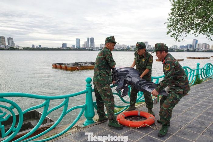 Các chiến sĩ đưa một thiết bị động cơ lên phương tiện nổi.