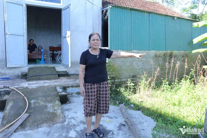 Bà Trần Thị Bang chỉ vào vị trí mảnh đất cạnh nhà mà vợ chồng bà đã bán để có tiền chạy chữa cho anh Nguyên. Ảnh: Thanh Hải