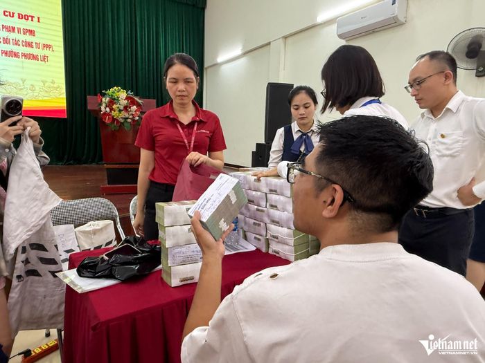Các hộ dân nhận tiền đền bù. Ảnh: Kiều Oanh