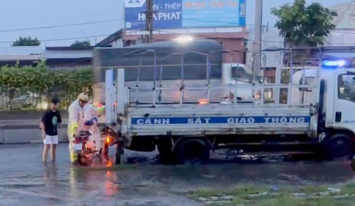 CSGT giúp đưa phương tiện của người dân qua điểm ngập. Ảnh: CSGT