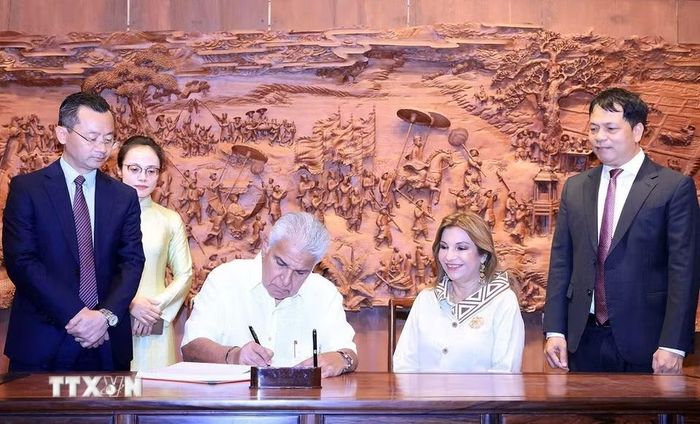 Tổng thống Cộng hòa Panama José Raúl Mulino và Phu nhân viết lưu bút tại khu Văn Miếu-Quốc Tử Giám. (Ảnh: Tuấn Anh/TTXVN)