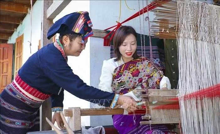 Du khách trải nghiệm nghề dệt truyền thống của đồng bào Lào ở bản Pa Xa Lào, xã Thanh Yên. Ảnh: Xuân Tư/TTXVN