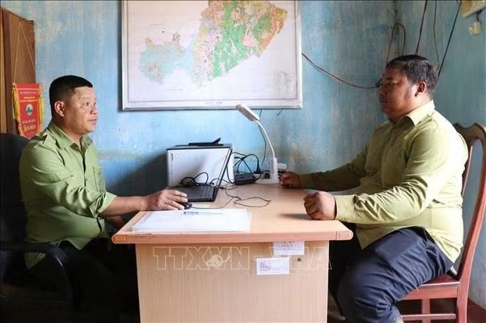 Anh K’Bàng (phía ngoài), thành viên tổ nhận khoán báo cáo tình hình quản lý, bảo vệ rừng với phụ trách Trạm Quản lý, bảo vệ rừng Nâm Sơ Ri, Vườn Quốc gia Tà Đùng (tỉnh Lâm Đồng). Ảnh: Nguyễn Huy Thành/TTXVN
