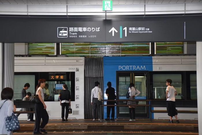 Hành khách đang đợi lên tàu LRT tại ga Toyama.
