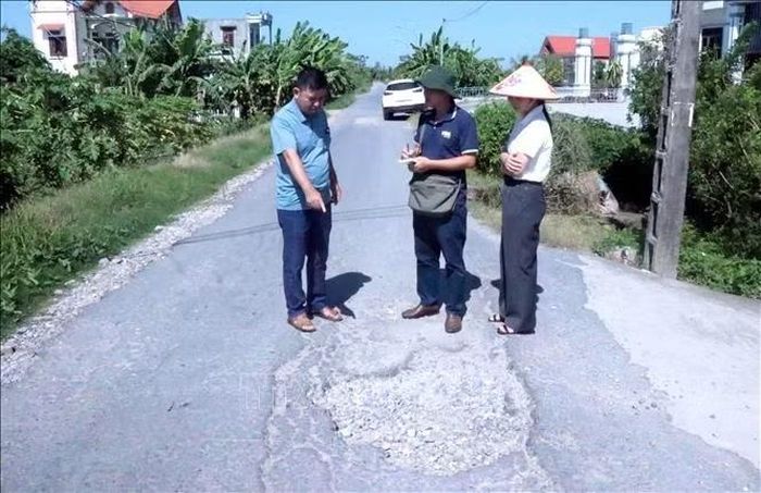 Cán bộ xã Thư Vũ, thôn Tiền Phong và phóng viên TTXVN khảo sát tình trạng xuống cấp của đoạn đê tả sông Hồng đi qua xã Thư Vũ. Ảnh: Sơn Hải/TTXVN