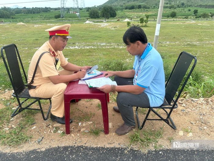 Cán bộ Cảnh sát giao thông kiểm tra giấy tờ của chủ phương tiện.