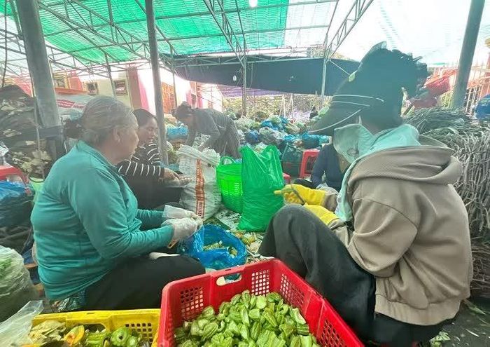 Nhóm phụ nữ đang sơ chế rau, củ phục vụ lễ hội.
