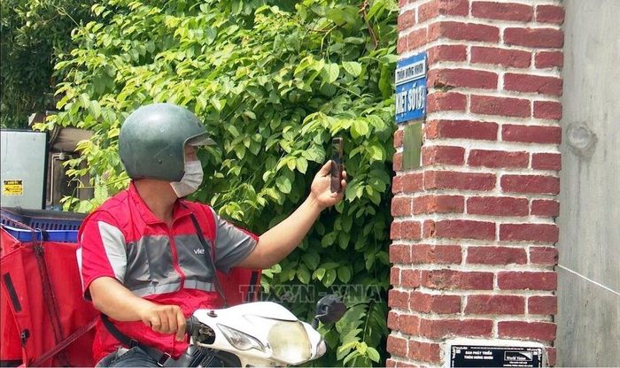 Mã QR gắn đầu các ngõ, hẻm đã tạo thuận lợi cho các shipper tìm địa chỉ giao hàng đến tận nhà người dân. Ảnh: Tá Chuyên - TTXVN