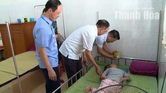 Cựu chiến binh Phạm Quang Thư (áo trắng) thăm hỏi nạn nhân nhiễm chất độc da cam/dioxin.