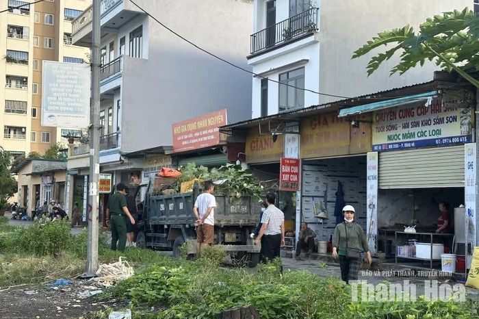 Lực lượng chức năng phường Hạc Thành thu dọn rác thải, cây cối, vật dụng bán hàng lấn chiếm hành lang giao thông tại khu vực quanh chợ Đông Vệ.