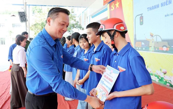  Đại diện Thành đoàn Bắc Ninh trao ấn phẩm tuyên truyền và mũ bảo hiểm cho đại diện Đội hình tuyên truyền bảo đảm an toàn giao thông Trường Trung học phổ thông Việt Yên số 2. 