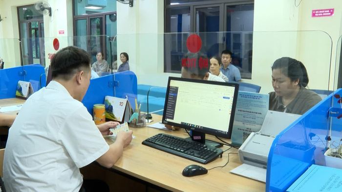 Cán bộ Trung tâm Phục vụ hành chính công hướng dẫn người dân sử dụng “Trợ lý Nhân dân” để hoàn thiện hồ sơ trực tuyến.