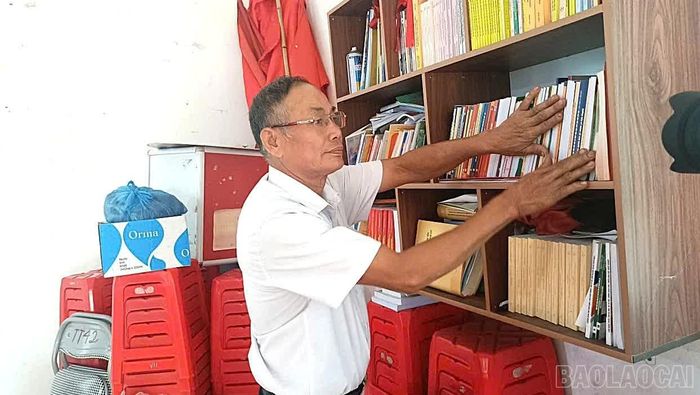 Ông Trần Văn Hường - Bí thư Chi bộ thôn Đồng Khê, xã Văn Chấn sắp xếp lại từng cuốn sách.