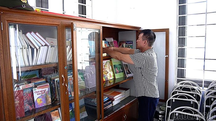 Ông Nguyễn Xuân Cương, tổ trưởng tổ dân phố Minh Tân 4, phường Yên Bái sắp xếp lại tủ sách của tổ dân phố.