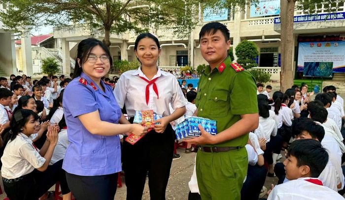 Đại úy Cao Nguyễn Khắc Dũ tặng quà cho học sinh trong buổi tuyên truyền pháp luật ở Trường THCS Hàm Thuận Bắc