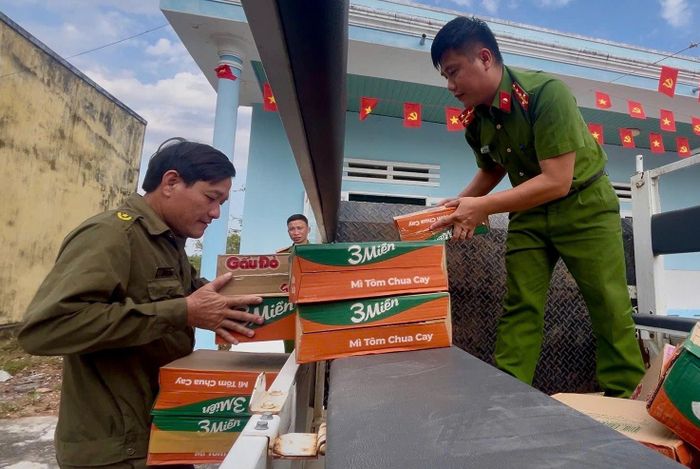 Đại úy Dũ cùng lực lượng an ninh cơ sở bốc dỡ nhu yếu phẩm từ trên xe, cứu trợ người dân lũ lụt