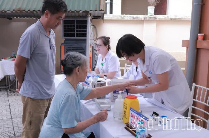 Nhân viên y tế Bệnh viện Đa khoa tỉnh Phú Thọ lấy mẫu xét nghiệm khám sức khoẻ định kỳ cho người cao tuổi ở phường Thanh Miếu.