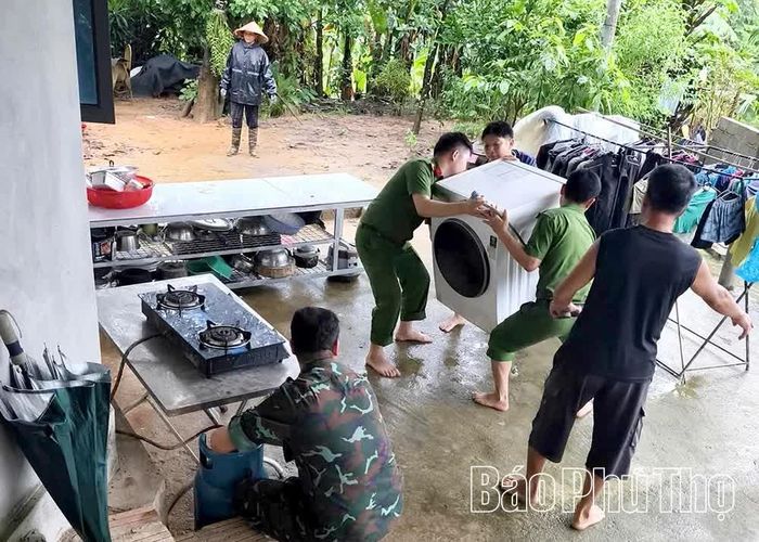 Công an xã Kim Bôi phối hợp các lực lượng hỗ trợ gia đình bị sạt lở đến nơi an toàn.