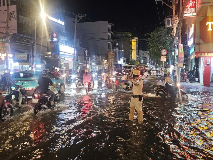 Lực lượng CSGT hướng dẫn phương tiện lưu thông qua khu vực ngập, hạn chế ùn tắc.
