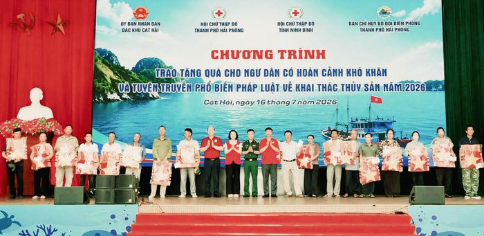 Đại diện các đơn vị phối hợp trao quà cho ngư dân có hoàn cảnh khó khăn tại chương trình tuyên truyền pháp luật về khai thác thủy sản ở đặc khu Cát Hải. Ảnh: Đông Hải