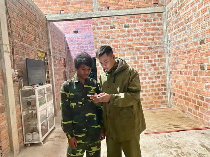 Trung úy Hồ Chí Lập gặt lúa giúp dân chạy lũ và giúp dân cài đặt các ứng dụng an sinh xã hội.