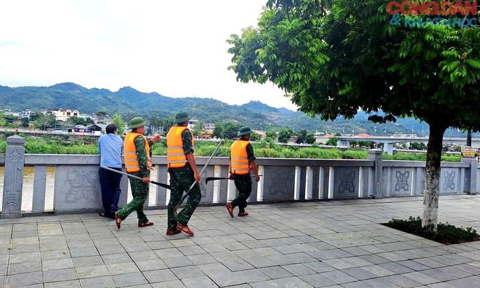 Lực lượng chức năng tìm kiếm nạn nhân phía bờ kè sông Hồng, phường Lào Cai. Ảnh: Quốc Hồng
