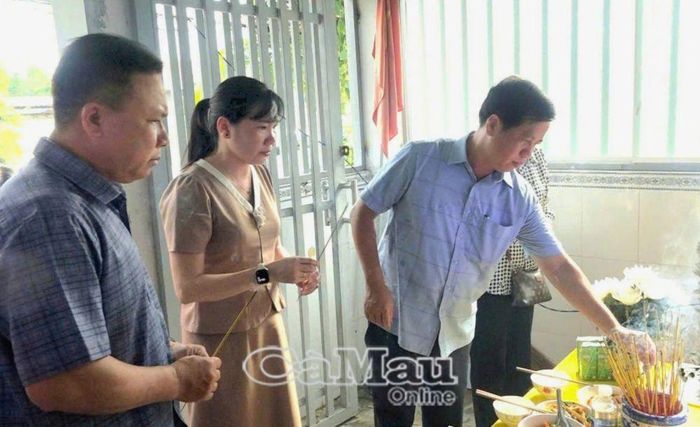 Đồng chí Huỳnh Minh Kiên (bìa phải), Bí thư Đảng uỷ, Chủ tịch HĐND xã Năm Căn, cùng các thành viên trong đoàn thắp hương cháu V.N.T.K., nạn nhân tử vong trong vụ án.