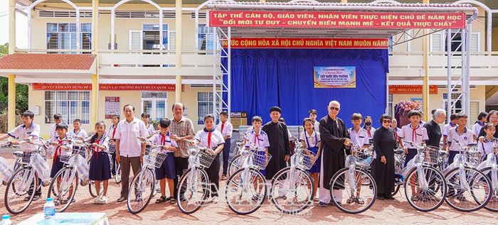 Lãnh đạo xã U Minh và nhà tài trợ trao xe đạp cho học sinh có hoàn cảnh khó khăn.