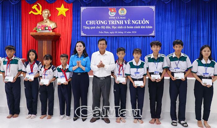 Phó Chủ tịch Thường trực Liên đoàn Lao động tỉnh Ngô Diễm Phúc (bên trái) và đồng chí Trần Trung Hiếu, Bí thư Đảng uỷ, Chủ tịch HĐND Xã Trần Phán, trao học bổng cho học sinh.