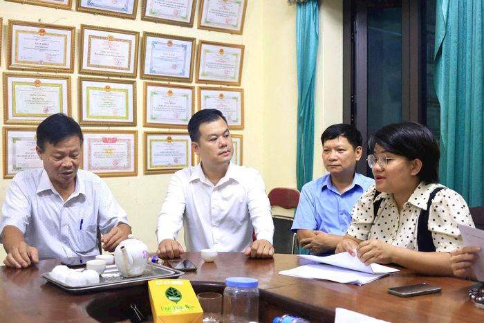 Cán bộ xã Thường Tín cùng cơ sở thôn Bình Vọng thống nhất phương pháp tuyên truyền, vận động người dân trên địa bàn giao dịch hàng hóa không sử dụng tiền mặt. Ảnh: PV