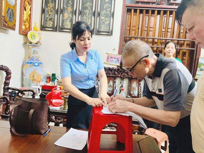 Bà Nguyễn Thị Kim Ngân, chuyên viên tiếp nhận hồ sơ tại Điểm hỗ trợ dịch vụ công số Hồng Vân, Chi nhánh số 1, Trung tâm Phục vụ hành chính công thành phố Hà Nội, đến tận nhà hỗ trợ người cao tuổi làm thủ tục hành chính. Ảnh: Hồng Vân