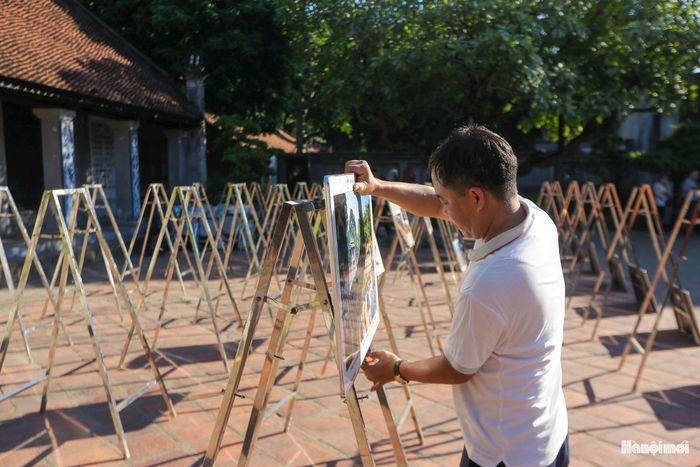 Các thành viên Ban Tổ chức cẩn trọng kiểm tra từng tác phẩm, từ ánh sáng, góc treo đến ma-két chú thích nhằm bảo đảm tính thẩm mỹ và hiệu quả thị giác cao nhất cho người xem.