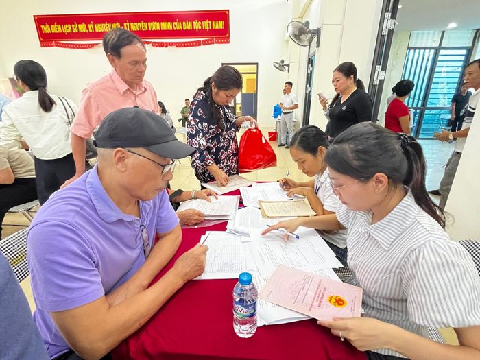 Các hộ dân thực hiện quy trình nhận tiền bồi thường. Ảnh: ND