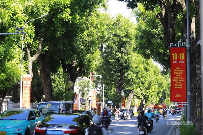 Người dân di chuyển dưới những hàng cờ đỏ trên phố. Ảnh: Tuấn Anh