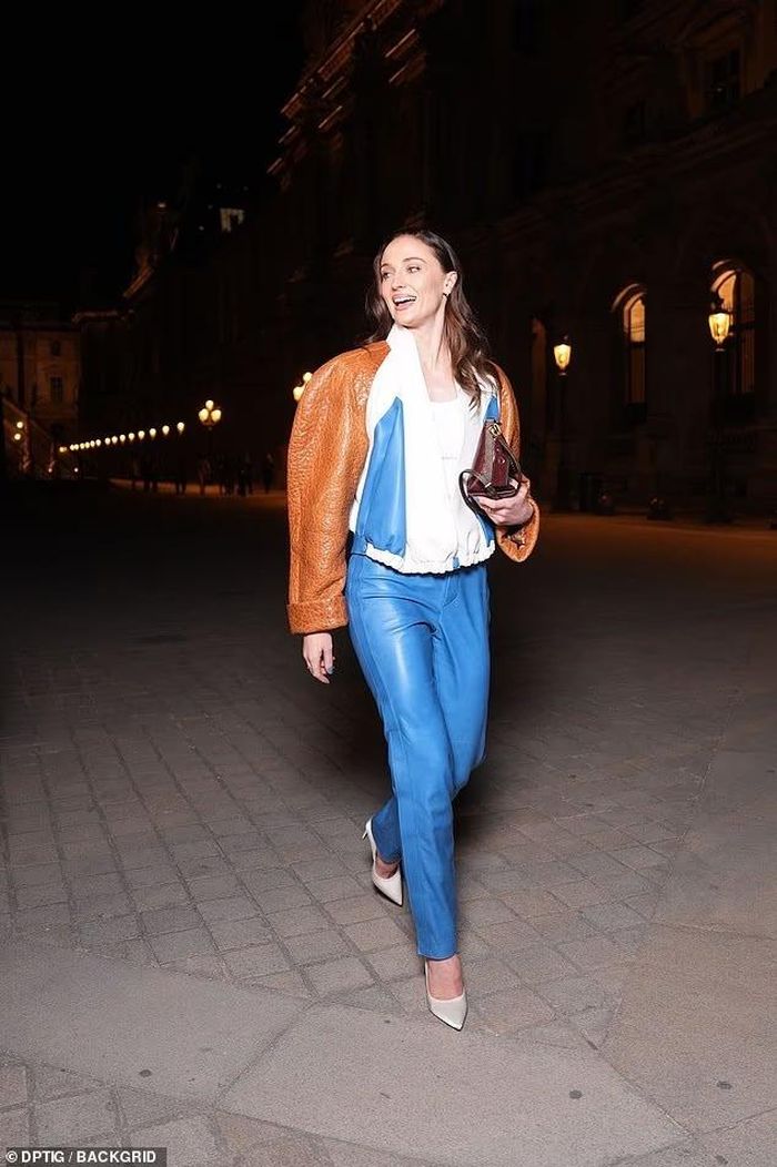 Sophie Turner xuất hiện trong bộ áo khoác da tông nâu - trắng, phối cùng quần xanh nổi bật. So với nhiều khách mời chọn váy hoặc các thiết kế cầu kỳ, Turner giữ hình ảnh cá tính, gọn gàng với chất liệu da và bảng màu tương phản, phù hợp phong cách khá mạnh mẽ cô thường theo đuổi tại các sự kiện thời trang. Ảnh: shutterstock, Backgird.