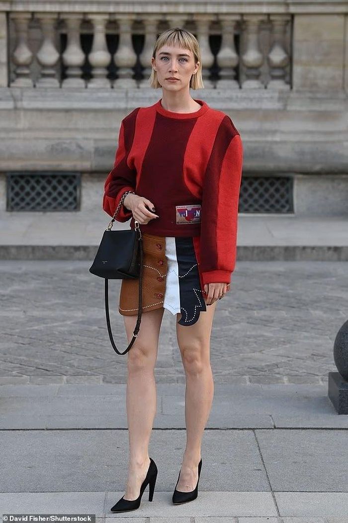  Saoirse Ronan góp mặt trong dàn khách mời khi Paris Fashion Week bước vào chặng cuối. Nữ diễn viên chọn diện mạo tương đối giản dị với áo len sọc đỏ, kết hợp chân váy da lộn, tạo tổng thể mang màu sắc cổ điển và nhẹ nhàng hơn so với nhiều thiết kế cầu kỳ tại sự kiện. Ronan hiện cũng là một trong những gương mặt gắn bó với Louis Vuitton tại nhiều sự kiện thời trang của hãng. Ảnh: shutterstock. 