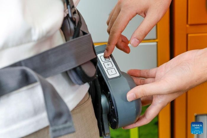  Nhân viên hướng dẫn du khách cách đeo robot khung xương tại khu thắng cảnh núi Qiyun, huyện Hưu Ninh, thành phố Hoàng Sơn, tỉnh An Huy, Trung Quốc, ngày 2/10. 