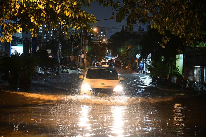 Nước ngập tới đầu gối, người dân lội bì bõm về nhà vào giờ tan tầm. Ảnh: Hoài Bảo.