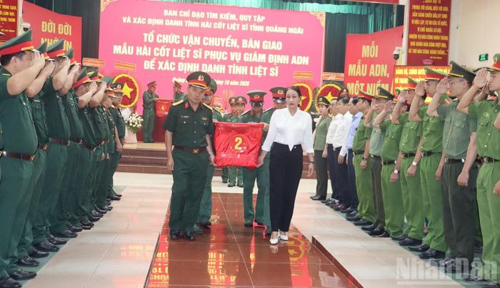 Các đại biểu thành kính, tiễn đưa mẫu sinh phẩm hài cốt các liệt sĩ bàn giao cho Viện Pháp y Quân đội phục vụ giám định ADN. (Ảnh: HIỂN CỪ)