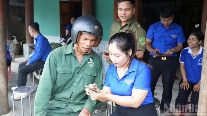Đoàn viên thanh niên xã hỗ trợ người dân kích hoạt tài khoản định danh điện tử mức độ 2. (Ảnh: THANH TÂM)