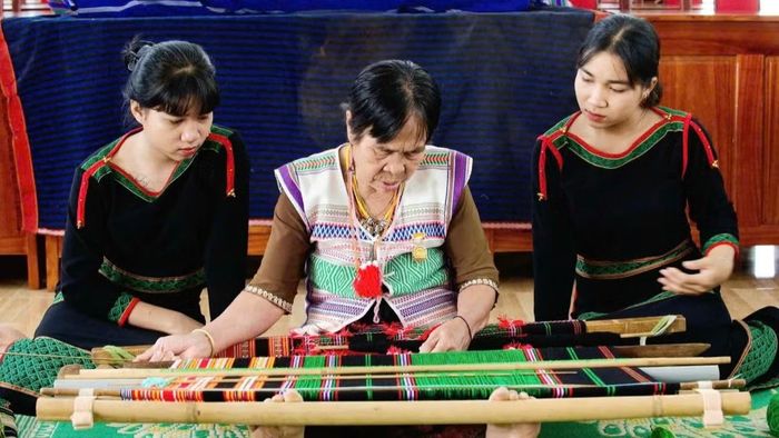 Bà Bờ Đam Thị Hạch (ngồi giữa) hướng dẫn cho con cháu. (Ảnh: HẰNG)