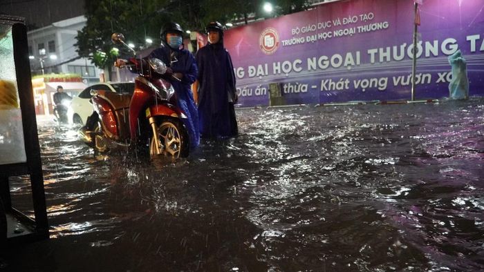  Sinh viên Trường đại học Ngoại thương vất vả di chuyển trong cơn mưa đúng lúc vào giờ cao điểm chiều 7/10. (Ảnh: VÕ LÊ)﻿. 