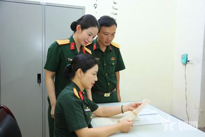 Cán bộ, nhân viên Bảo tàng Quân khu 4 đọc thư của liệt sĩ Nguyễn Phú Tường. Ảnh: HOÀNG TRUNG
