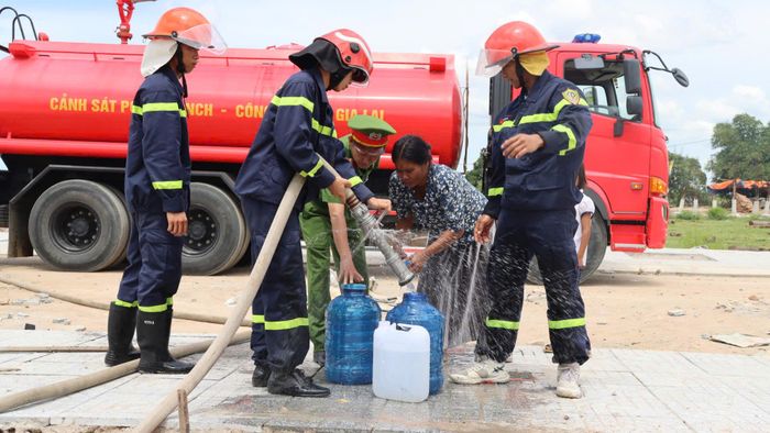  Các chiến sĩ công an mang nước sạch cho người dân tái định cư. Ảnh: HỮU PHÚC 