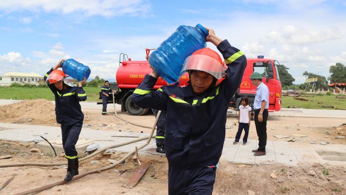  Cán bộ chiến sĩ tất bật vận chuyển nước vào tận nhà. Ảnh: HỮU PHÚC 