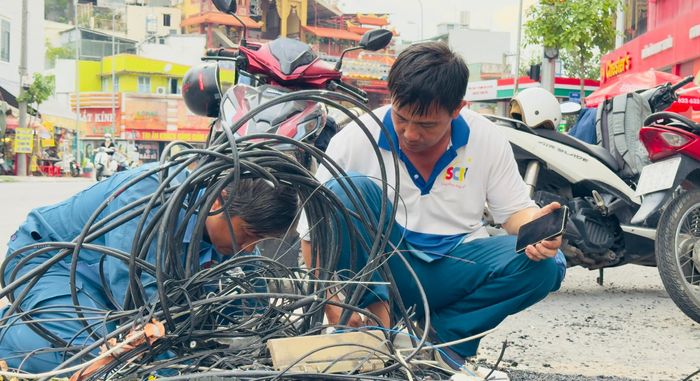  Các đơn vị phối hợp ngầm hóa cáp viễn thông trên đường Chu Văn An. Ảnh: ĐÌNH DƯ 