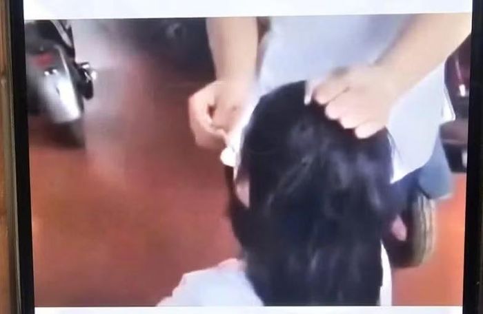 Nữ sinh dùng thuốc lá dí vào mặt bạn. (Ảnh: Cắt từ clip)